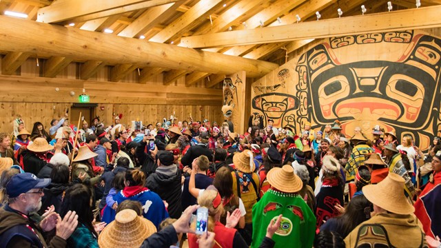 Large gathering inside an Alaska Native tribal house