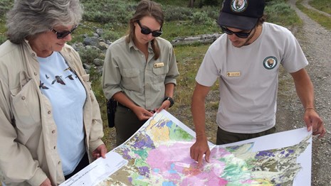 photo of 3 people holding a large map
