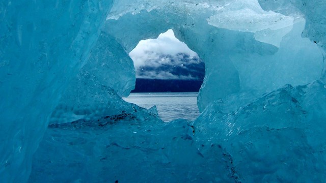 Photo of a glacier ice cave from inside looking out to open water