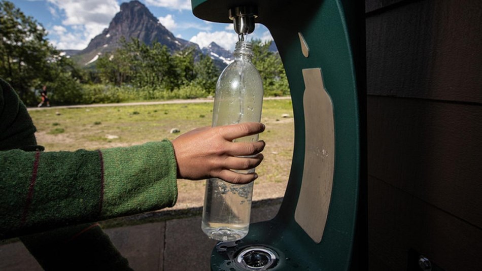 A person fills a water bottle at a water bottle filling station