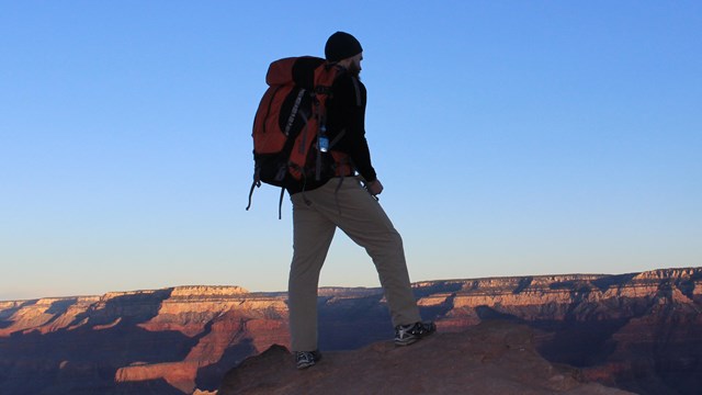 A hiker coming up over the horizon in Grand Canyon