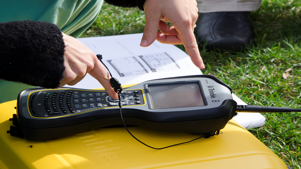 A person typing data into a machine that sits on a yellow box