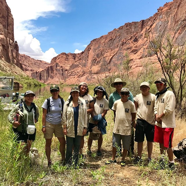 group of volunteers standing in canyon area surrounded by red rock formations