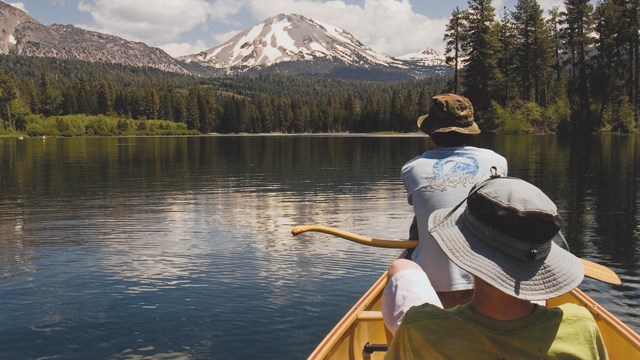 Two recreationalists in a kayak enjoying smooth waters in a glacial lake