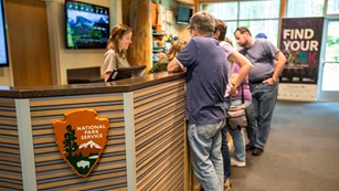A park ranger speaking with visitors at an information desk