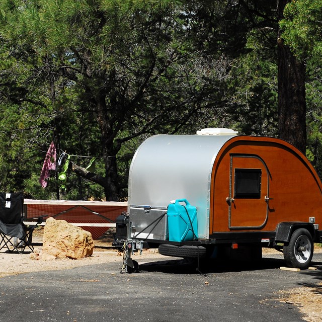 small old camper trailer parked at campsite