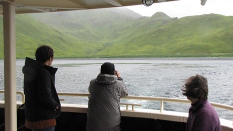 A view of Attu and boat passengers from the deck of a boat.