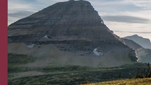 grey mountain in front of a cloudy sky