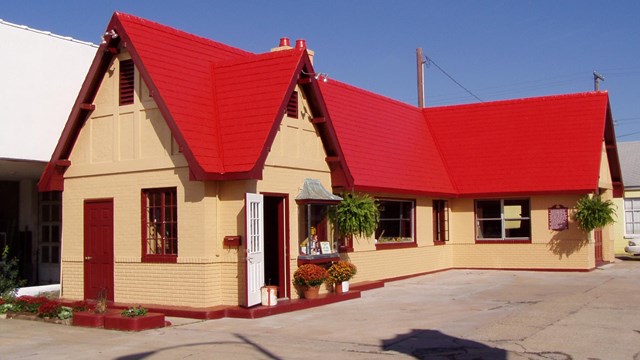 A small wooden house with a red roof.