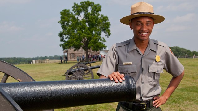 A ranger poses by a Civil War cannon.