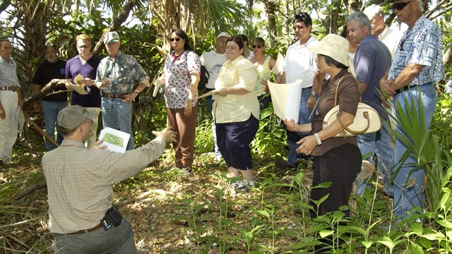 Archeologist speaking with public at field site