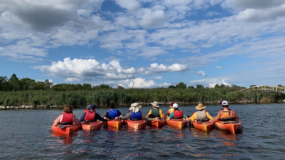 Kayakers link arms on a sunny summer day