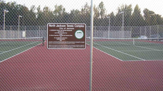 Sign on a tennis court fence
