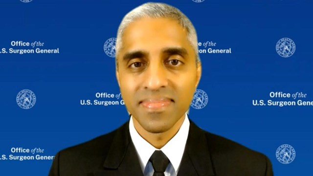 man in black uniform with a blue banner in background that reads Office of US Surgeon General