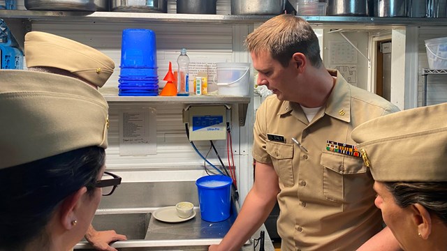 PHS Officers assist inspect a kitchen in a park