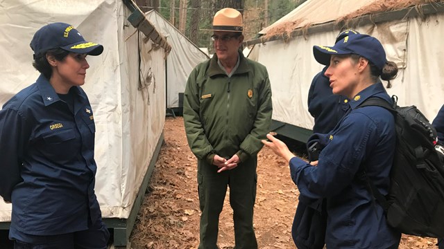 public health service officers discuss park operations with NPS employee