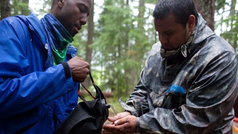 Youth cleans hands with water from a canteen.