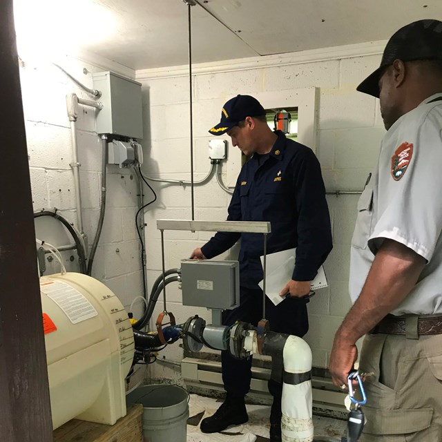 PHS Officer inspects well water pump 