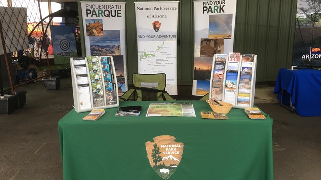 A table with green tablecloth and brochures on it.