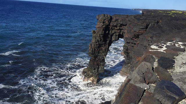 Black Hōlei Sea Arch reaching out of the ocean