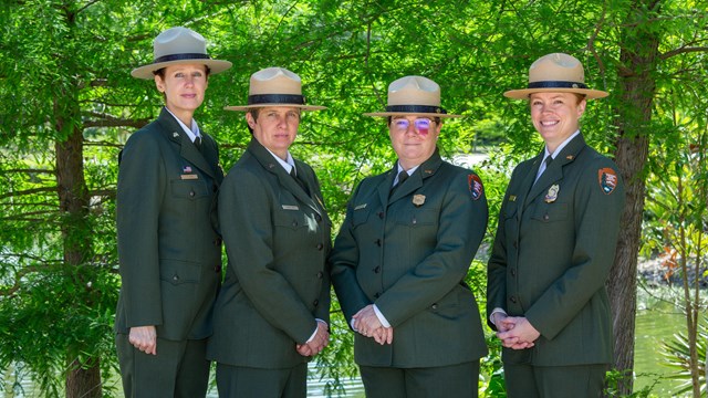 Four park rangers standing outside