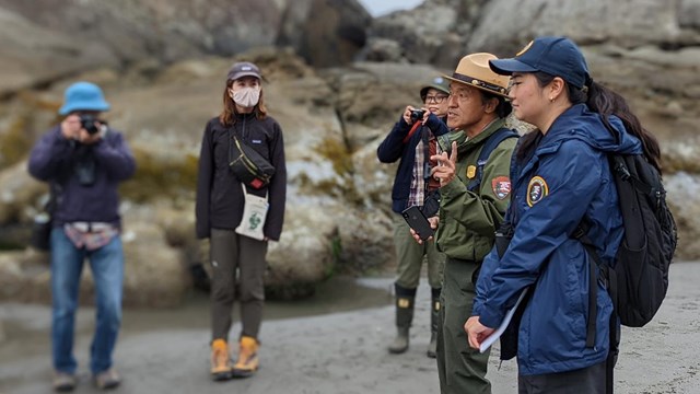 A park ranger and international volunteers talking to an international group 