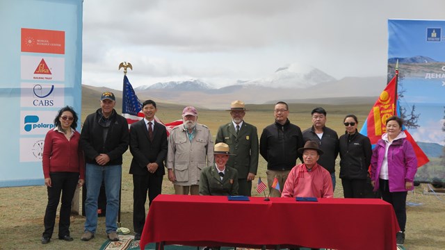 An international delegation and National Park Service staff at a signing event 
