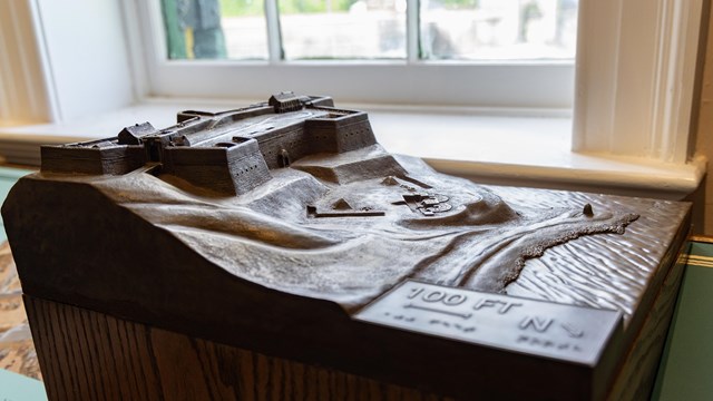 A bronze model of a fort as part of a informational exhibit.