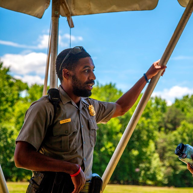 A ranger chats in a tent.