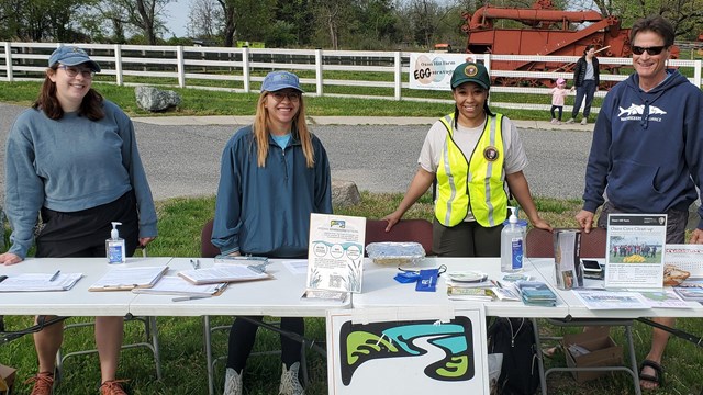 Volunteers standing behind a table. 