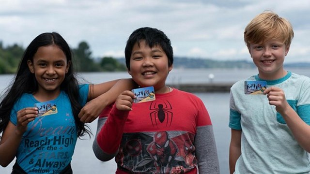 Three children pose for a photo.