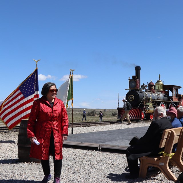 Group gathered for an event in front of a historic train 