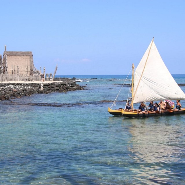 Double hulled canoe passing in front of Hale o Keawe temple during the parks Cultural Festival. 