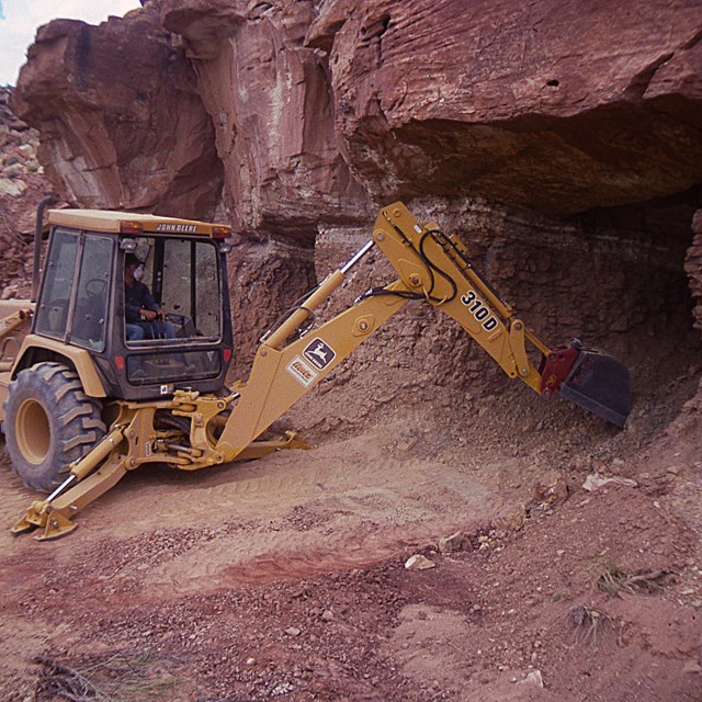 tractor being used to backfill a mine opening