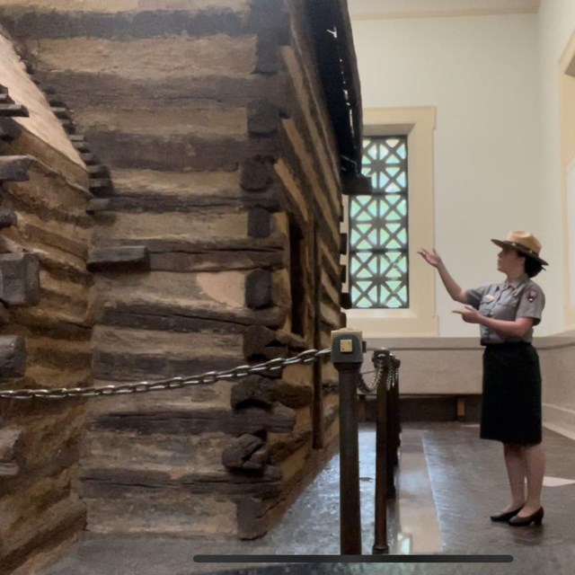 Ranger standing near log cabin