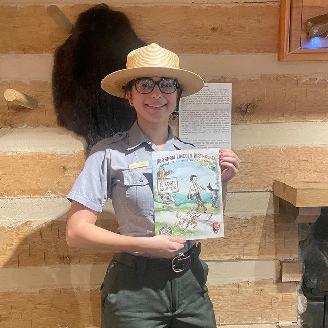 Park ranger holding Jr Ranger book