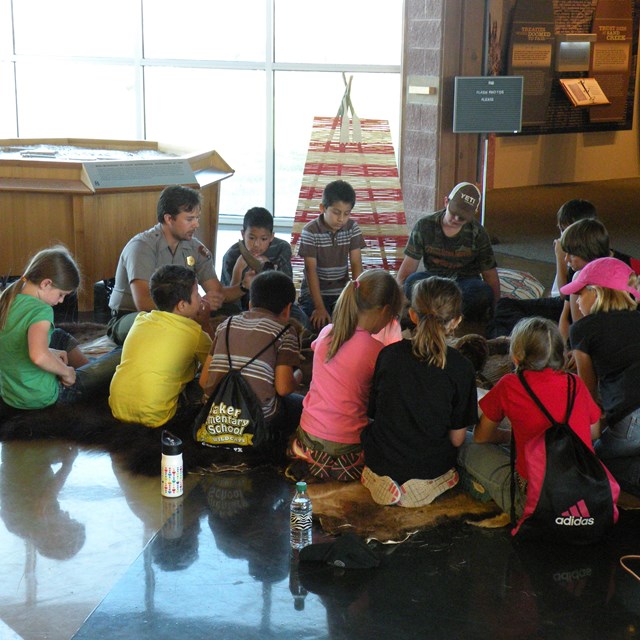 School group sitting on the floor of a visitor center