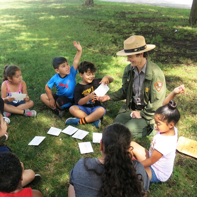 Ranger and kids sitting on ground in a circle