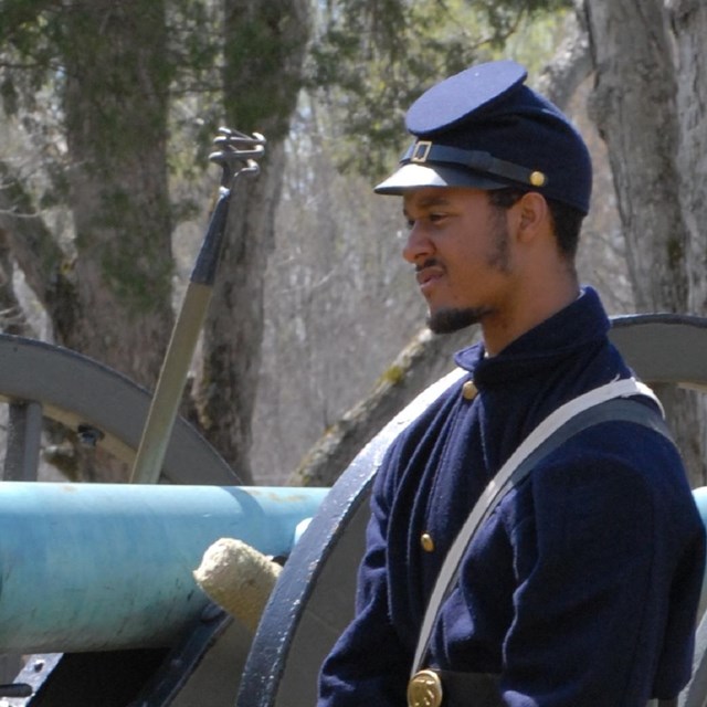 USCT Artillery reenactor next to a cannon