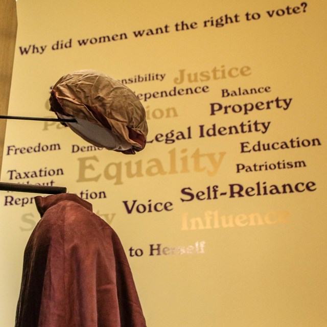 Suffragist hat and cloak in a museum exhibit 