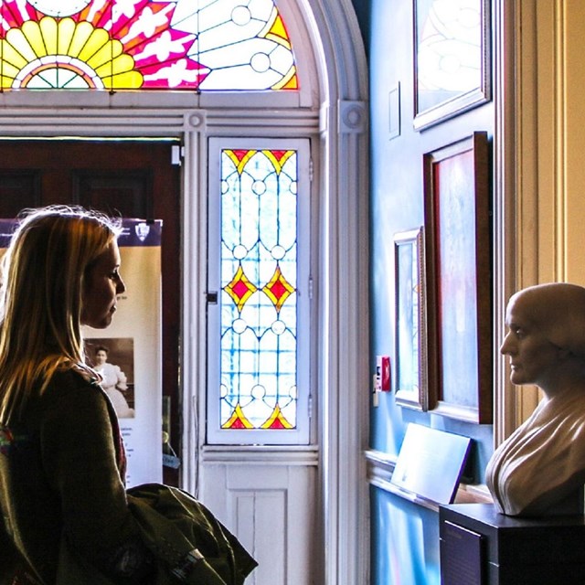 Visitor looking at busts of suffragists