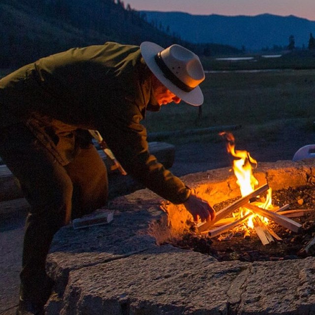 Ranger lighting a campfire