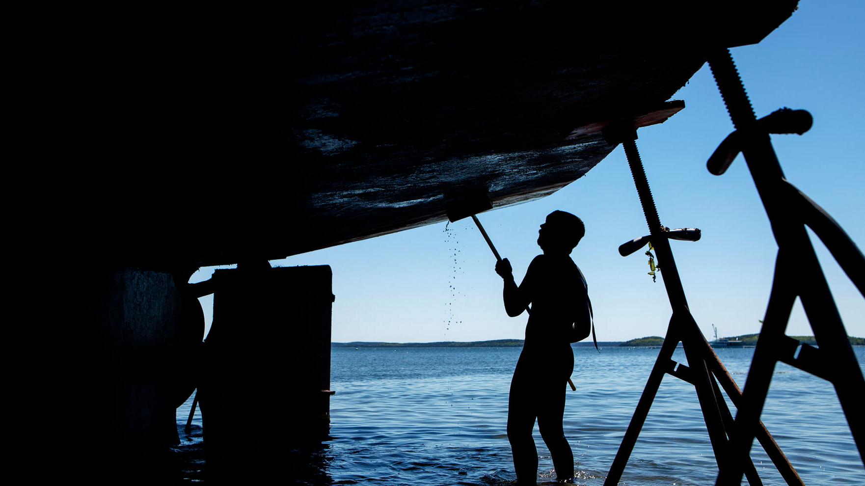 Deck hand Joe Mandusa works to clean the underside of the 151&prime; Schooner Margaret Todd in Hulls Cove