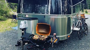 Airstream with stove and bicycles next to it