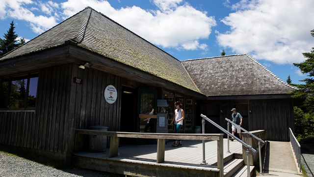 A brown gift shop building with stairs and an accessible ramp