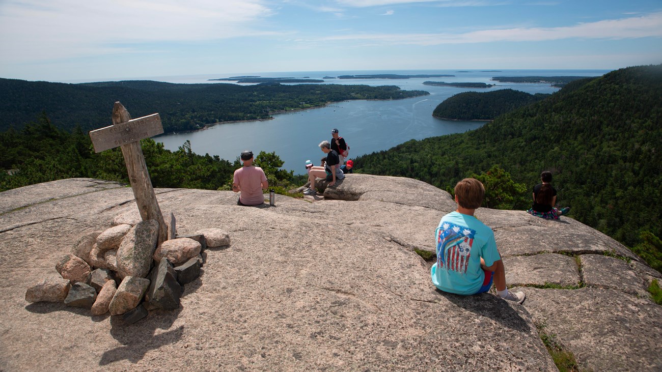 People on a mountain summit overlooking water