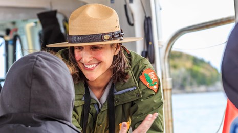 Park ranger talks with a visitor on a boat program.