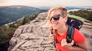 Woman clings to iron rung on steep trail