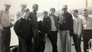 B&W Photo of men standing in front of a car