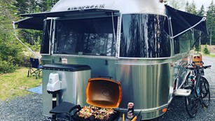 Airstream trailer with barbecue and bicycles outside